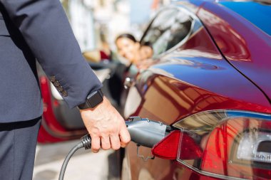 Close up of a fuel nozzle being put into the car clipart