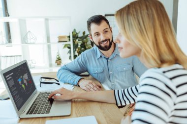 Gülümseyen adam izlerken meslektaşım infographics laptop okuyun