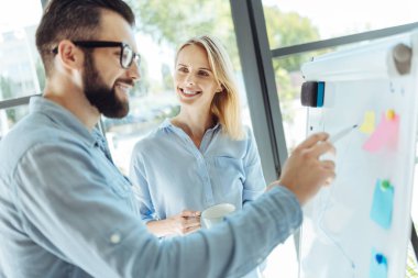 Sakallı adam beyaz tahta sopa ile bir grafik çizim