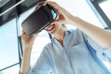 Bir Vr kulaklık giyen neşeli genç kadın