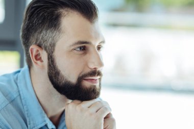 Yakışıklı sakallı adam çenesini katlanmış ellerde dinlenme