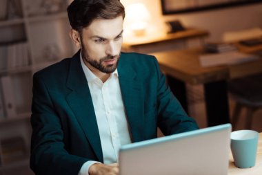 Diz üstü kullanarak ciddi ofis çalışanı