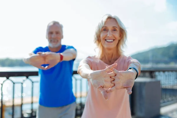 Cheerful elderly couple working out on the bridge — Stock Photo, Image
