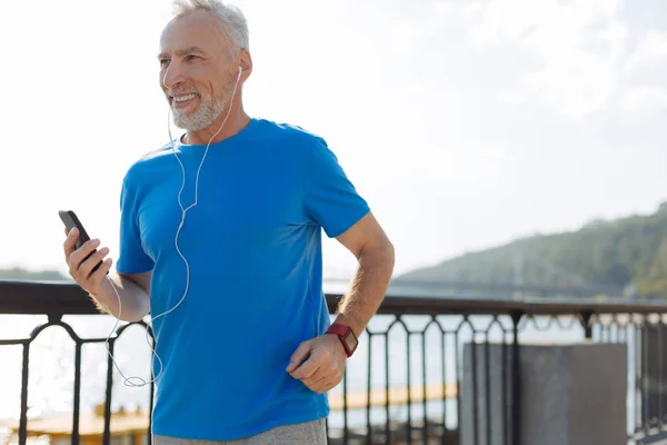 ジョギングと音楽を聴いて元気な年配の男性 — ストック写真