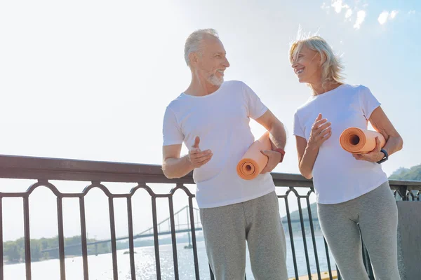 Lovely senior couple walking with yoga mats — Stock Photo, Image