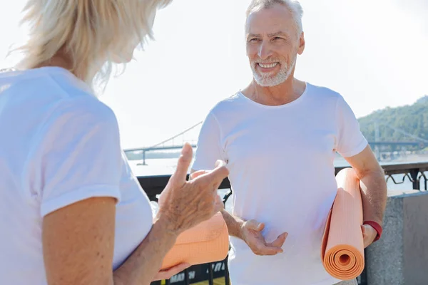 Upbeat senior man and woman talking about yoga — Stock Photo, Image