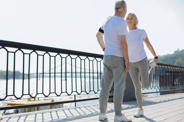 Cheerful woman stretching and leaning on husbands shoulder — Stock Photo, Image