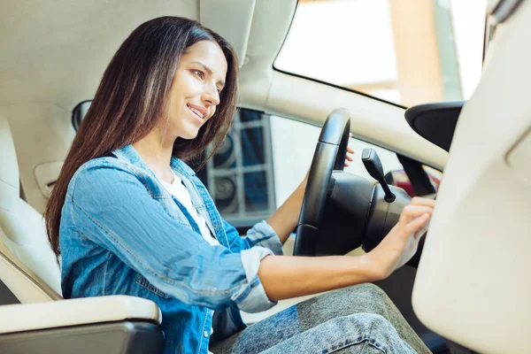 Encantada mulher agradável sentado ao volante — Fotografia de Stock