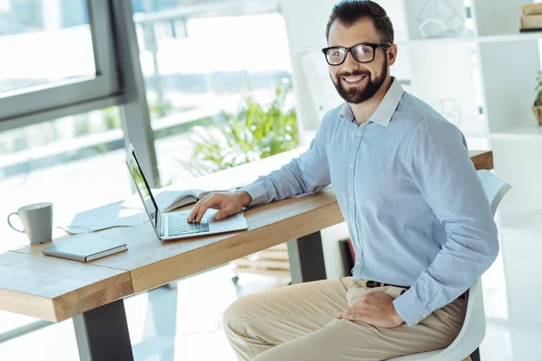 남자 작업 노트북에서 작업 하는 동안 포즈 미소 — 스톡 사진