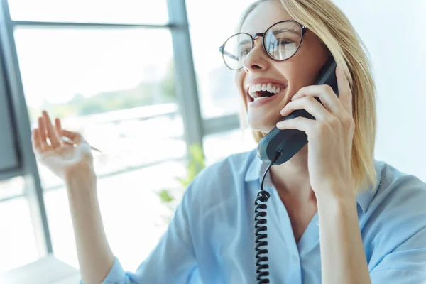 Happy woman laughing while talking on the phone — Stock Photo, Image
