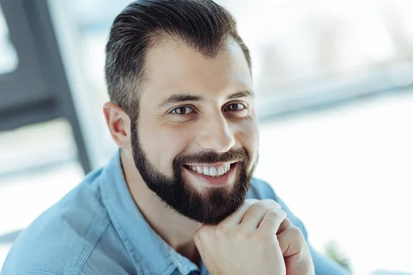 Hombre alegre apoyando su barbilla en las manos y sonriendo —  Fotos de Stock