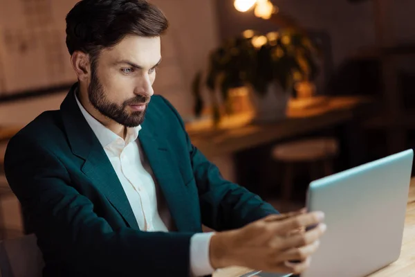 Внимательный бизнесмен смотрит на свой ноутбук — стоковое фото