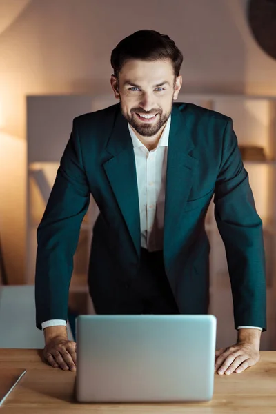 彼のコンピューターの前に立っている肯定的なマネージャー — ストック写真