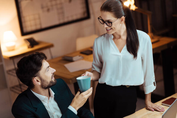 Cheerful female person listening her colleague