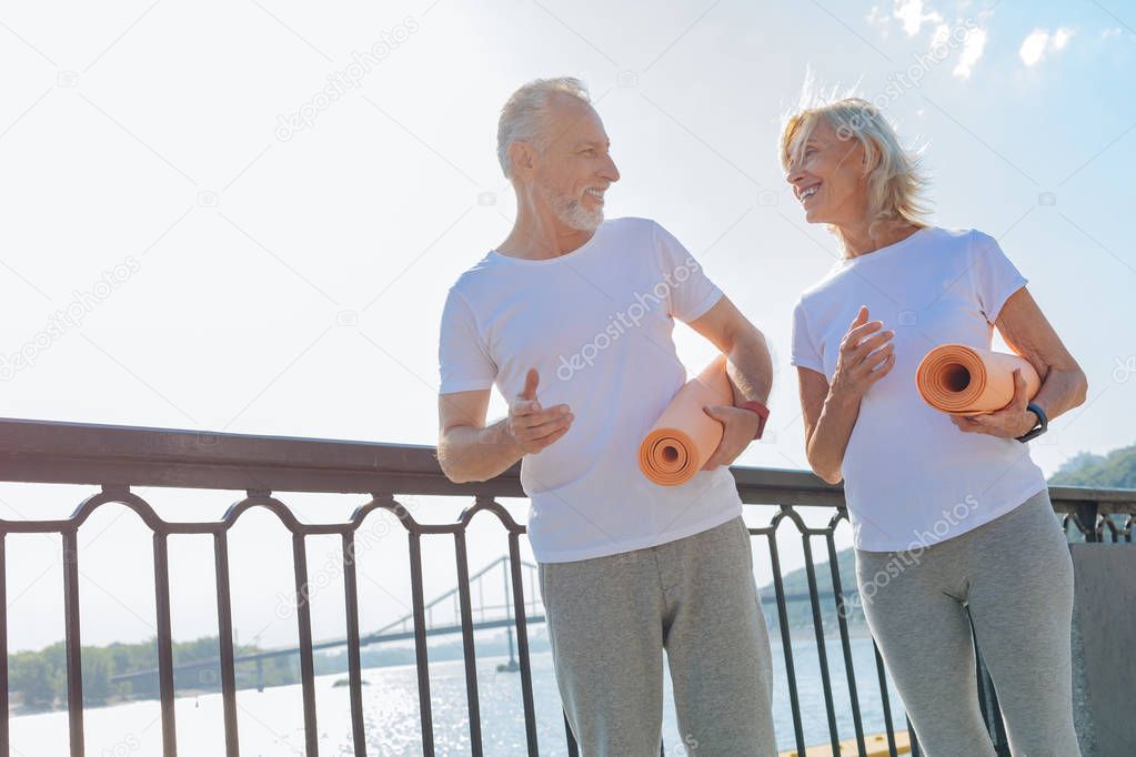 Lovely senior couple walking with yoga mats
