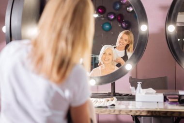 Gülümseyen Kuaför müşteri saç kesimi ile deneme