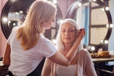 Kadının kişisel stilist onun kirpik rimel uygulamak