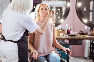 Müvekkili için göz gölgeler uygulayarak üst düzey makyaj sanatçısı