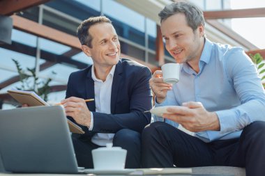 İş ortağı ile oturan memnun olumlu iş adamı