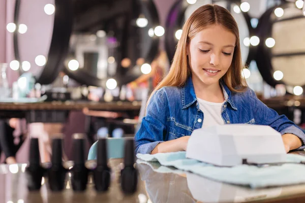 Pleasant girl drying her nails in the nail studio — Stock Photo, Image