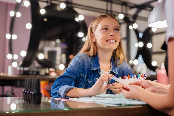 Adorable girl telling manicurist about desired nail color — Stock Photo, Image