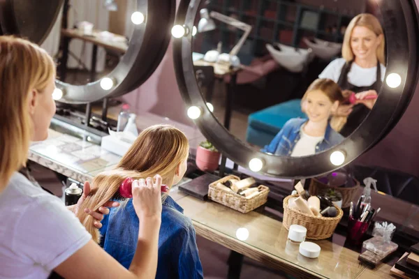 Cabeleireiro agradável cuidar do cabelo das meninas — Fotografia de Stock