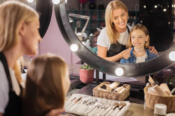 Hermoso artista de maquillaje dando toques finales a las niñas maquillaje —  Fotos de Stock