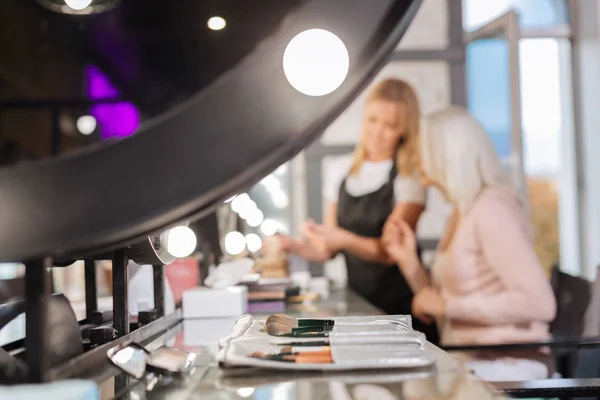 Pinceles de maquillaje colocados sobre la mesa en el salón de belleza — Foto de Stock