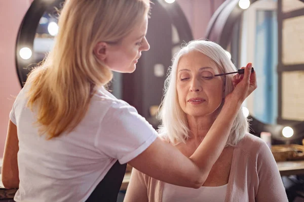 Petite makeup artist applying mascara to her clients eyelashes — Stock Photo, Image