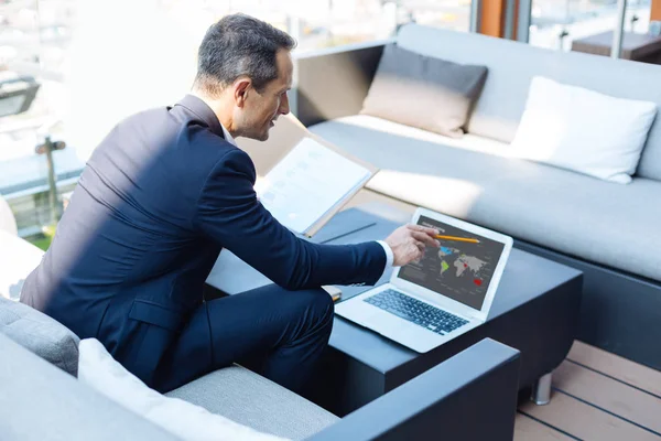 Inteligente hombre de negocios guapo estudiando estadísticas mundiales —  Fotos de Stock