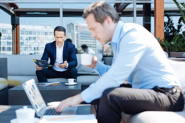 Ernstige leuke zakenman zijn smartphone kijken — Stockfoto