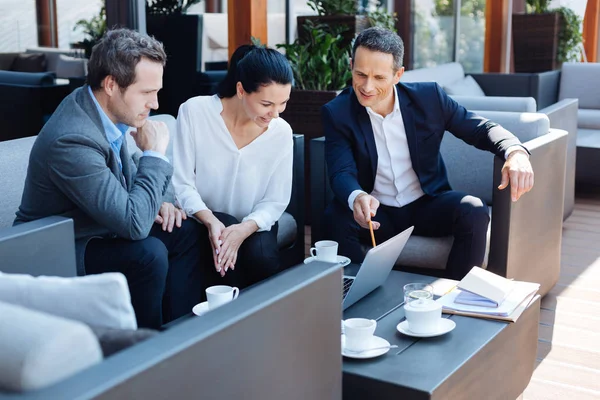 Onun iş ortakları ile oturan neşeli güzel kadın