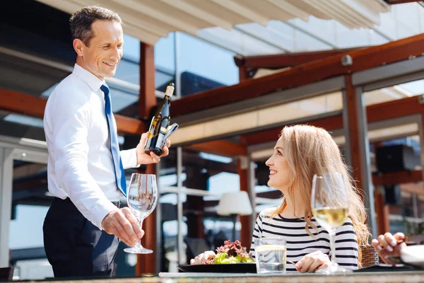 Χαρούμενα επαγγελματίας σερβιτόρος βάζει ένα ποτήρι στο τραπέζι — Φωτογραφία Αρχείου