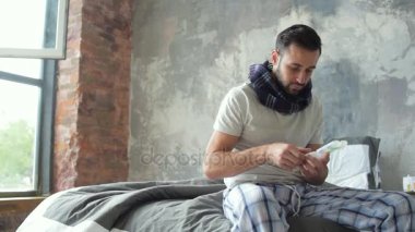 Yatakta otururken yorgun hasta adam alarak hap