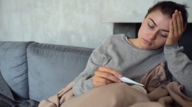 Hayal kırıklığına uğramış kadın sıcaklık termometresi ile denetleniyor