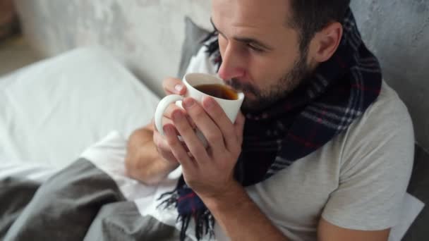 Close up of ill man drinking tea in bed — Stock Video