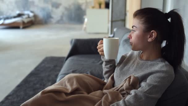 Morena agotada disfrutando de su taza de té aromático — Vídeos de Stock