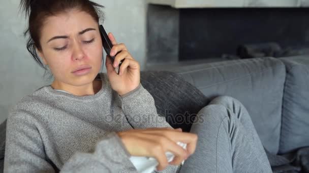 Разочарованная больная женщина разговаривает по телефону дома — стоковое видео