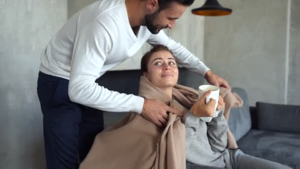 Loving millennial man covering ill wife with blanket — Stock Video