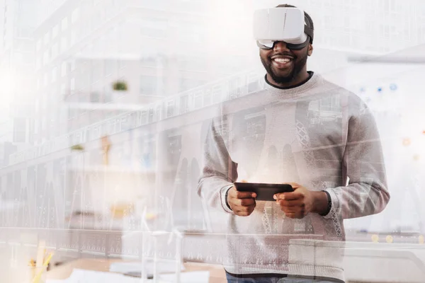 Jeune homme optimiste avec masque de réalité virtuelle et tablette — Photo