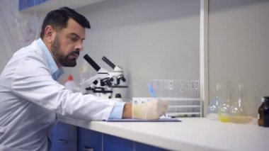 Mikroskop ve not almak seyir stetoskop deneyimli bilim adamı