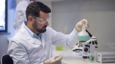 Sıvı şişesi deneme sırasında bırakarak odaklı adam