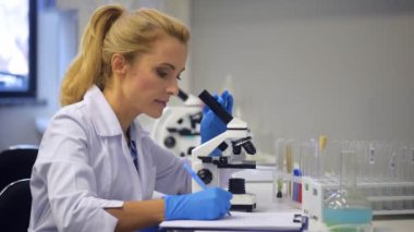 Mikroskop kullanma ve gözlemler yazma akıllı olgun Bayan