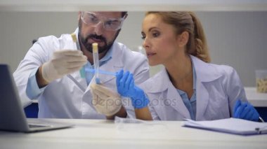 Pozitif fikirli meslektaşım üzerinde test tüpleri kimyasal sıvılar ile sohbet