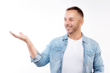 El ile bir şey gösteren gülümseyen yakışıklı