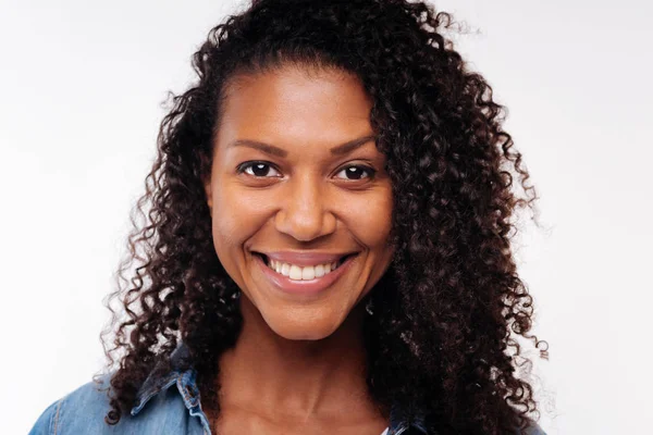 Close up of pretty curly woman smiling at camera — Stock Photo, Image