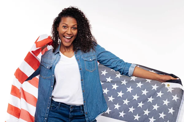 Счастливая женщина, завернутая в американский флаг — стоковое фото