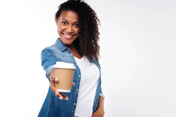 Dark-haired woman stretching out hand with coffee cup — Stock Photo, Image