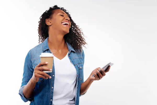 Mujer alegre riendo de mensaje mientras toma café —  Fotos de Stock