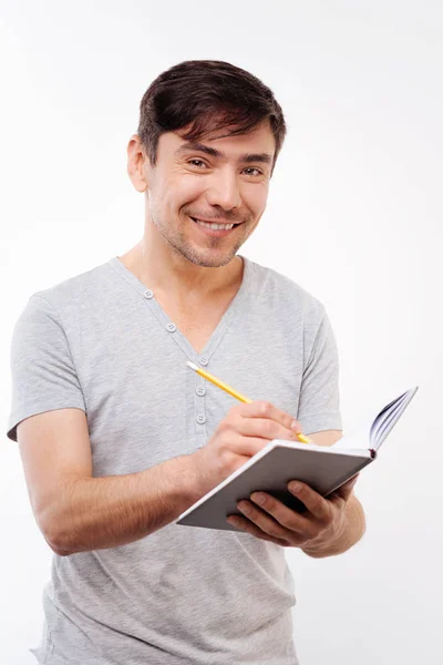 Agradável cerdas homem fazendo anotações no caderno — Fotografia de Stock